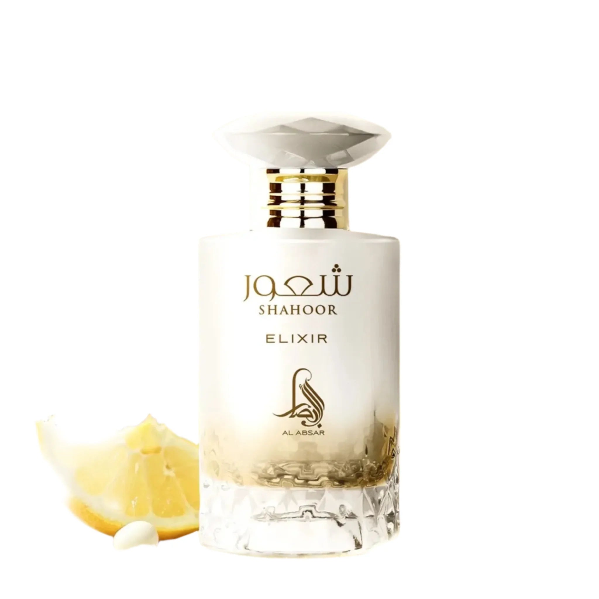 A bottle of Al Absar Shahoor elixir perfume with top notes listed as lemon, candy, and rum, middle notes as orange blossom and milk, and base notes as vanilla, benzoin, amber, and musk, presented alongside slices of lemon and a bar of soap.