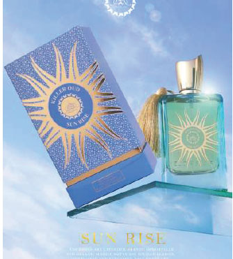 A perfume bottle with a turquoise liquid labeled 'Sun rise' next to its packaging box, both featuring a golden sun design.